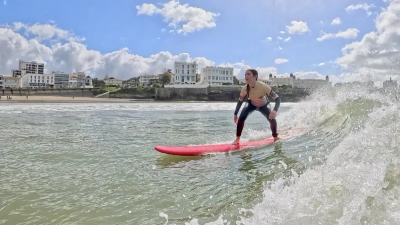 Élève de surf sur planche rouge à Pontaillac
